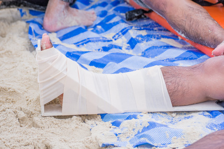 first aid by elastic bandage around right legの写真素材