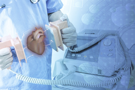 doctor hold paddle EKG and AED monitor shock heart