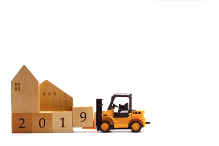 Yellow toy forklift hold wooden letter block number 9 to complete word 2019 isolated on white...