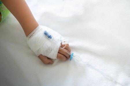 Close up of saline solution on child's hand who fever patients on in hospital.の写真素材