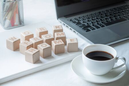 Wooden blocks of word Work from home on desk with laptop computer and coffee cup. Self-quarantine...