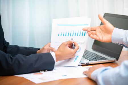 Closeup two businessmen discussing on business reports with many of graphs and charts. Business and financial concept.の写真素材