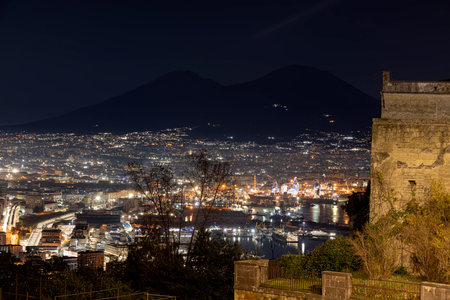 Night view of the city of Naples, captured from San Martino, in the Campania region of Italy, showcasing both Mount Vesuvius and the port of Naplesの写真素材