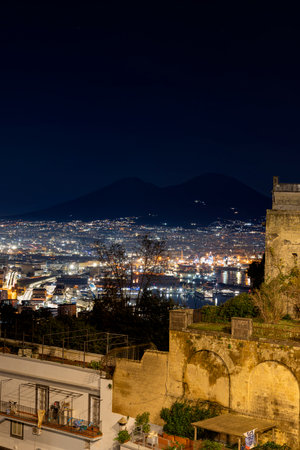 Night view of the city of Naples, captured from San Martino, in the Campania region of Italy, showcasing both Mount Vesuvius and the port of Naplesの写真素材