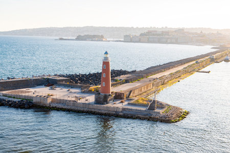 Photograph taken in Naples, Italy, showing a view of the lighthouse at Molo San Vincenzo, captured from a cruise shipの写真素材