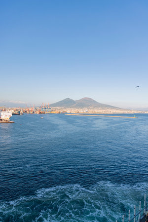 Photograph taken in Naples, Italy, featuring a view of Mount Vesuvius and the sea, captured from a cruise shipの写真素材