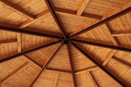 Interior view of a pitched timber roof showing the ridge, rafters and sheathingの写真素材