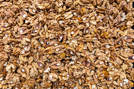 Cracked walnuts cores with more nuts as background.の写真素材