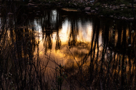Reflections of the sunset in the water of the river. Late in the field.