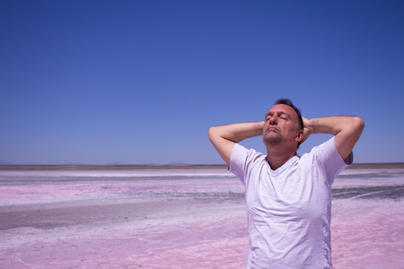 Man with his hands behind his head and his eyes closed in a salt.の写真素材