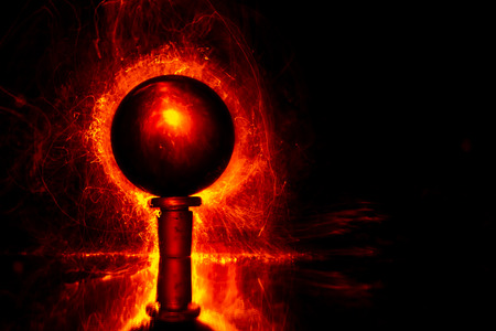 Red lights in the form of tiny luminous fibers behind a transparent sphere. Light painting photography.の写真素材