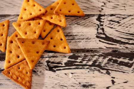 Salty cookies in a triangular shape on a white and black rustic board. Food for snack.の写真素材