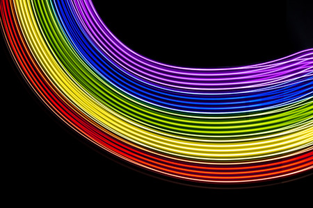 Rainbow of light. Photography made with light painting. Abstract lines with the colors of the rainbow on black background. Resource for designers.の写真素材