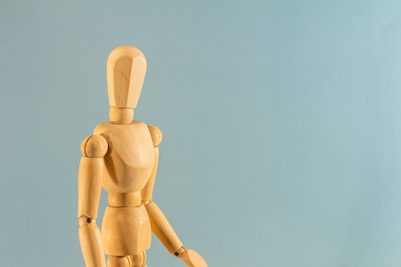 Wooden doll as a model for drawing on a neutral background. Concept of asking for help, sadness, loneliness and begging.の写真素材