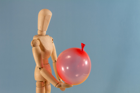 Wooden doll as a model for drawing on a neutral background. Concept of playing in solitude, bulling, separation and sadness.の写真素材