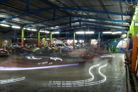 Porto Seguro, Brazil. August 14, 2018. Bumper cars in a traveling amusement park. Long exposure photography. Cars leave the trail of light in their path.の写真素材