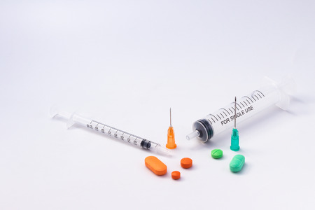 Colorful pills on white background. Syringes with the legendの写真素材