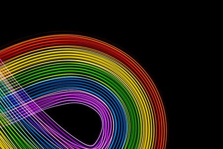 Multicolor lights on black background. Rainbow of vibrant colors curves. Space to write.の写真素材