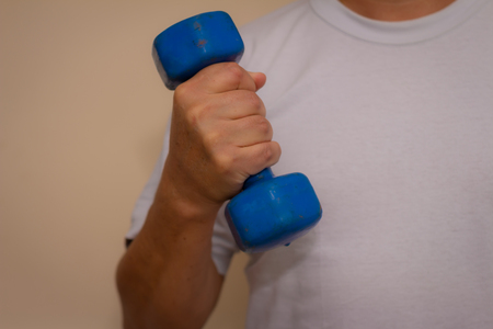 Man exercising in the gym. Exercises to tone muscles. Concept of health care.の写真素材