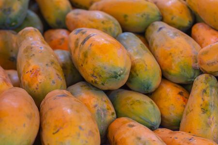 Papaya in the market. Fruit of orange pulp with countless small seeds. Exotic tropical fruit from...
