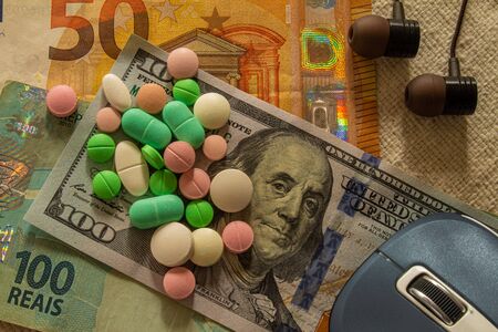 Desk with bills and medicines. Concept of cost of health and drug addiction. Copy space