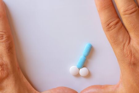 Hands of a man next to pills that symbolize a penis with an erection. Male metaphor. Medicine related to male impotence. Virility concept.の素材 [FY310133216063]