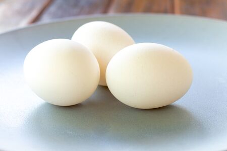 Chicken eggs on a plate and a wooden table. Copy Space Organic and natural food. Vegetarian food.