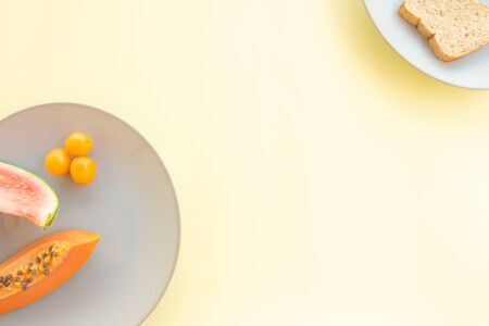 Tropical fruits on a neutral plate. Free space to write. Natural food for breakfast.の写真素材