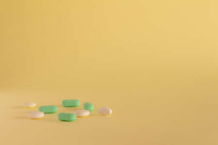 Medicines on a neutral yellow background. Drugs for legal use. Pharmaceutical industry. Concept of medication abuse. Medicines for medicinal use. Copy spaceの写真素材