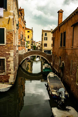 Venice Italy. May 15, 2018. Boats stopped in the canals of the Italian city. A few people walk through the alleys.のeditorial素材