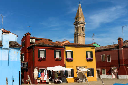 Burano, Italy. May 21, 2016. Tourists stroll through the colorful city of Burano. Brightly colored houses in the northern Italian city on a sunny day.のeditorial素材