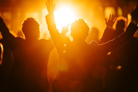 Silhouettes of people dancing at a music festival, backlightの素材
