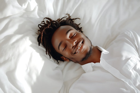 Young african american man sleeping on bed at home, top viewの素材