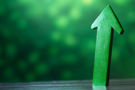 Green arrow on green bokeh background. Business growth concept.の素材