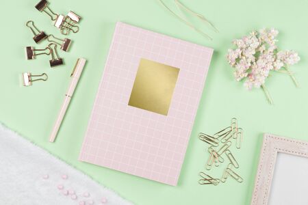 flat lay stationery on work desk in green pastel backgroundの写真素材