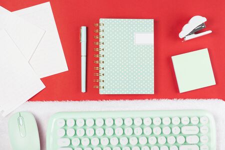 flat lay stationery on work desk in red pastel backgroundの写真素材
