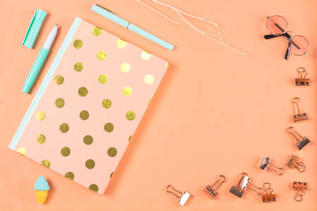 flat lay stationery on work desk in orange pastel background