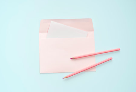 flat lay pink letter and pencil stationery on blue pastel floor background