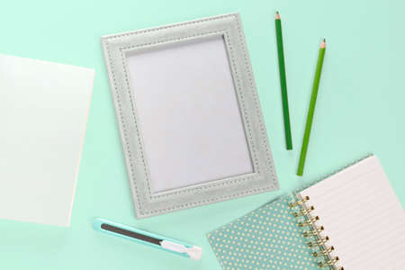 flat lay picture fream and stationery on green pastel backgroundの写真素材