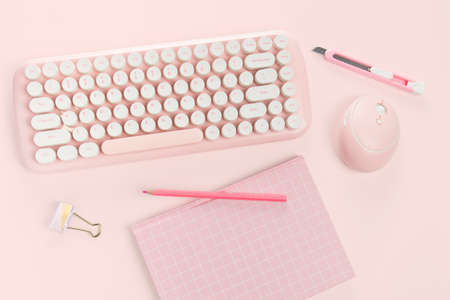 flat lay pink book stationery and keyboard on pink backgroundの写真素材