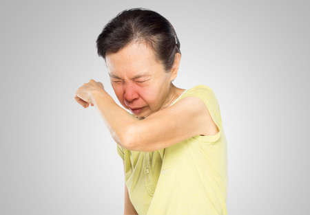 old asian woman has bacterial infection on her elbow from sneezeの写真素材