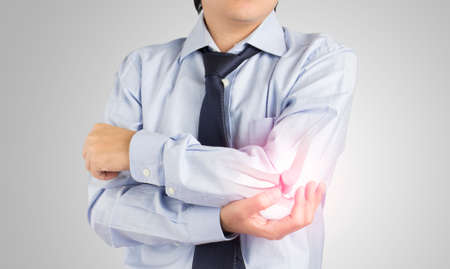 office worker feels pain elbow , elbow bones injury on gray backgroundの写真素材