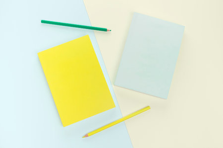 flat lay book and pencil stationery on green yellow backgroundの写真素材