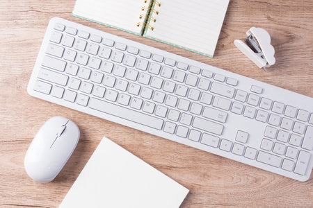 flat lay keyboard and stationery on wooden backgroundの写真素材