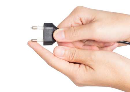 closeup hand holding electrical plug and power socket on white background