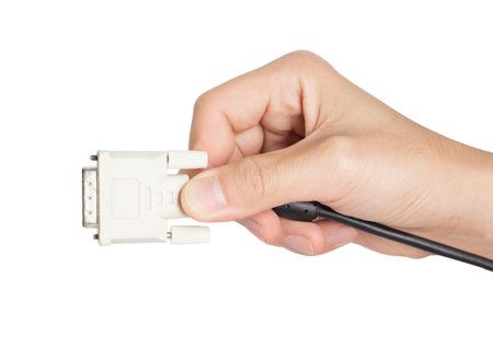 closeup hand holding computer dvi cable plug and power socket on white backgroundの写真素材