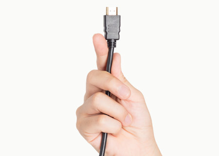 closeup hand holding computer HDMI cable plug and power socketの写真素材
