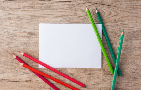 flat lay colored pencils and paper  stationery on wooden backgroundの写真素材