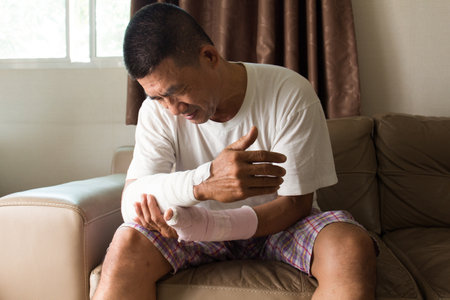 asian man broken arm feeling sadの写真素材