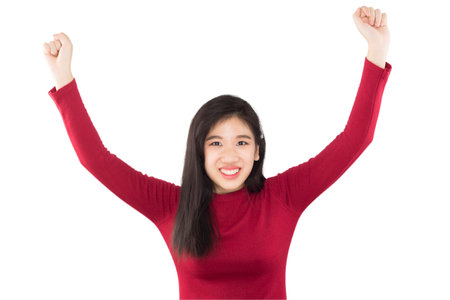 young asian girl raises her hands to express happiness , feel victoryの写真素材